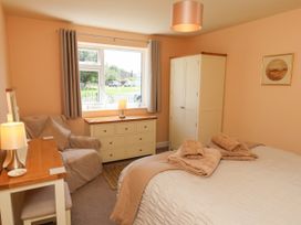 A bedroom with a bed and armchair at Wheeldale Cottage in Goathland