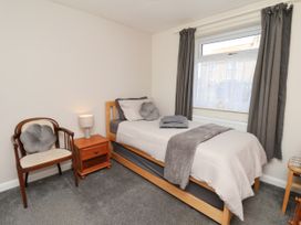 A bedroom with a bed and a chair at Wheeldale Cottage in Goathland