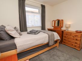 A bedroom with a bed and dresser at Wheeldale Cottage in Goathland