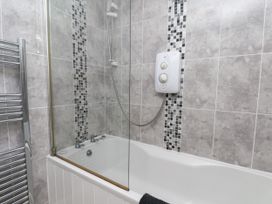 A bathroom with a bath tub and shower at Wheeldale Cottage in Goathland