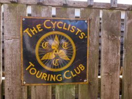 A sign for The Cyclists' Touring Club on a wooden fence