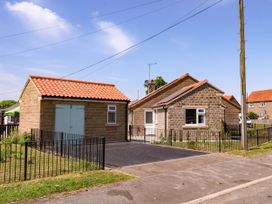 A house with a shed and fenced area at Wheeldale Cottage in Goathland