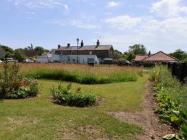 A garden with grass and flowerbeds at Wheeldale Cottage in Goathland