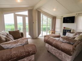 A living room with sofas and a television at Plot 34 Carlisle