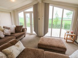 A living room with a sofa and a coffee table at Plot 34 Carlisle