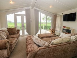 A living room with sliding doors and sofa at Plot 34 in Carlisle