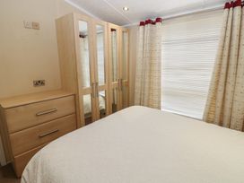 A bedroom with a bed and wardrobe at Plot 34 Carlisle