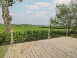 An outdoor view from a deck overlooking fields and trees at Plot 34 Carlisle