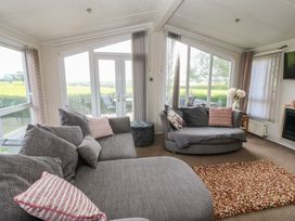 A living room with sofas and a door to the outside at Plot 34 near Armathwaite