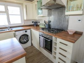A kitchen with a washing machine and stove at Plot 34 near Armathwaite