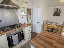 A kitchen with a stove and dining table at Plot 34 near Armathwaite