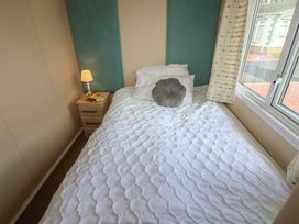 A bedroom with a bed and nightstand at Plot 34 near Armathwaite