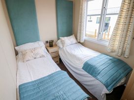 A bedroom with two single beds and a nightstand at Plot 34 near Armathwaite