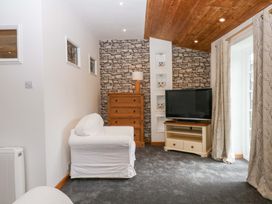 A living room with a sofa and TV at The Headmasters Quarters in Chudleigh