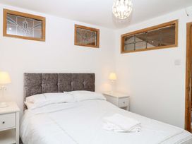 A bedroom with a bed and bedside lamp at The Headmasters Quarters in Chudleigh
