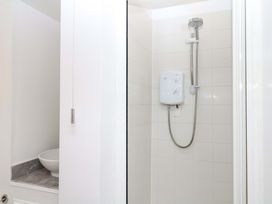 A shower with a showerhead and control unit in a bathroom at The Headmasters Quarters Chudleigh