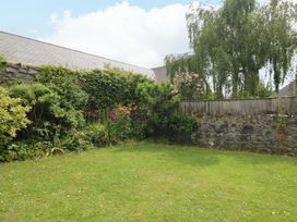 A garden with grass and flowering plants at The Headmasters Quarters in Chudleigh
