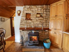 A living room with a fireplace and wood stove at Gullane East in Rathmore, County Kerry