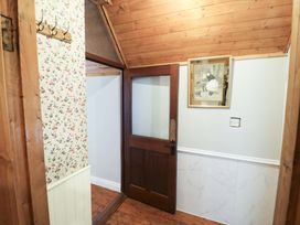 A hallway with coat hooks and a wooden door at Gullane East in Rathmore, County Kerry