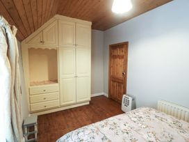A bedroom with a bed and a cupboard at Gullane East in Rathmore, County Kerry