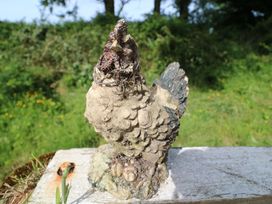 A chicken sculpture on a wooden surface in an outdoor setting at Gullane East, Rathmore, County Kerry