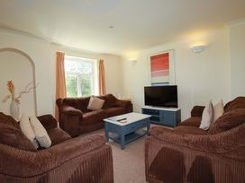 A living room with sofas and a television at 4 bed number 2 Atlantic Reach near St Columb Road