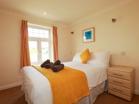 A bedroom with a bed and nightstand at 4 bed number 2 in Atlantic Reach near St Columb Road