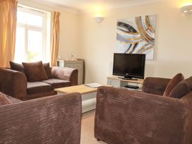 A living room with a television and seating at 4 bed number 20 Newquay