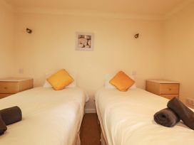 A bedroom with two single beds and bedside cabinets at 4 bed number 20 Newquay