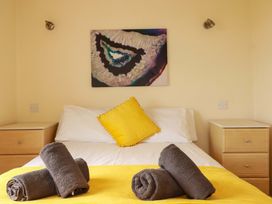 A bedroom with a bed and yellow pillow at 4 bed number 20 Newquay