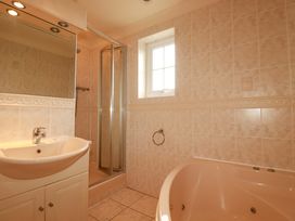 A bathroom with a bathtub and shower at 4 bed number 20 Newquay