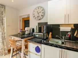 A kitchen with appliances and a bar stool at La'al Yan in Branthwaite