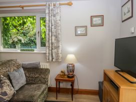 A living room with a sofa and television at La'al Yan in Branthwaite