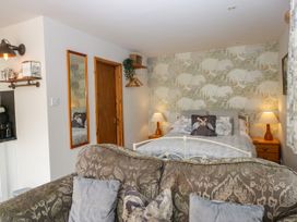 A bedroom with a bed and sofa at La'al Yan in Branthwaite
