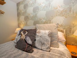 A bedroom with decorative pillows and a lamp at La'al Yan in Branthwaite