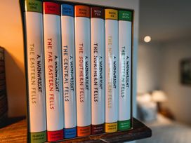 A collection of Wainwright books on a shelf at La'al Yan in Branthwaite