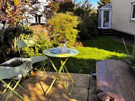 A garden with a table and chairs at La'al Yan in Branthwaite