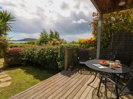 A garden with a table and chairs on a deck at Little Gem in Weymouth
