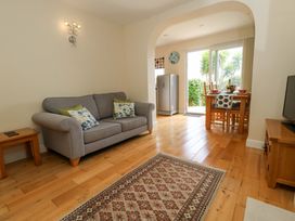 A living room with a sofa and dining area at Little Gem in Weymouth