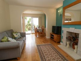 A living room with a sofa and a dining table at Little Gem in Weymouth