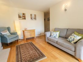 A living room with a sofa and armchair at Little Gem in Weymouth