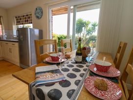 A dining room with a table set for a meal at Little Gem in Weymouth
