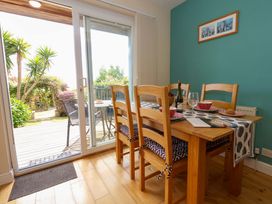 A dining room with a table and chairs at Little Gem in Weymouth