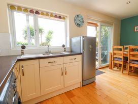 A kitchen with a sink and refrigerator at Little Gem in Weymouth