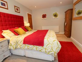 A bedroom with a red bed and furniture at Little Gem in Weymouth