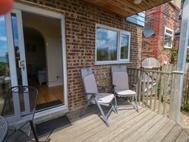 A deck with chairs and door at Little Gem in Weymouth