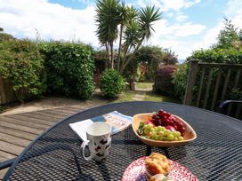 A garden scene with a table set for refreshments at Little Gem in Weymouth
