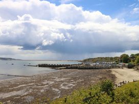 A view of the shoreline with a pier and boats at Little Gem in Weymouth