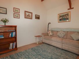 A living room with a couch and bookshelf at Cider Cottage