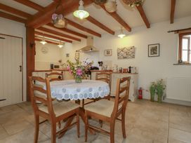 A kitchen with a dining table and chairs at Cider Cottage